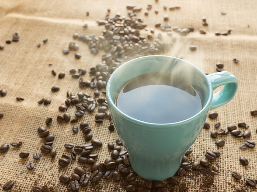 Kaffeebecher und Kaffeebohnen auf Leintuch